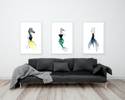 Three wall posters depicting fashion illustrations with animal heads illustrated with markers hanging above the sofa in the living room.